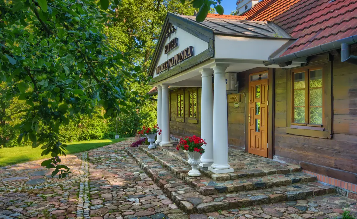 Historická budova Hotelu Dworek Wapionka obklopená zelení